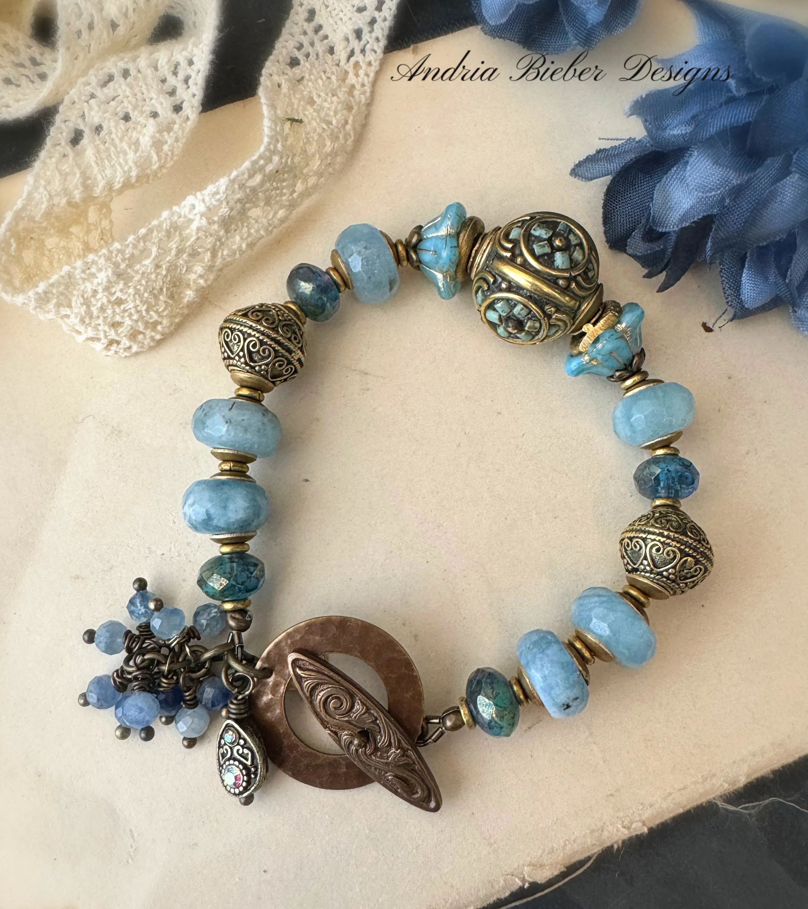 Aquamarine stone, African brass, Czech glass, Indonesian bead with flower detail.